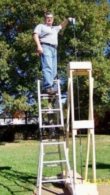 Person on a ladder using the 10FtDrillBit extension on a job site